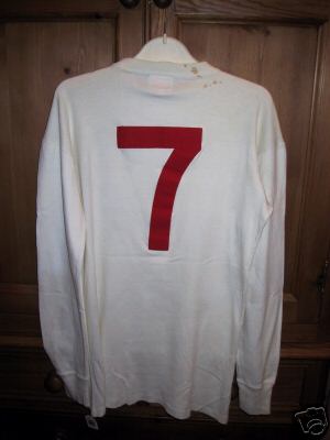 It is a white round collared Umbro no 7 number shirt.