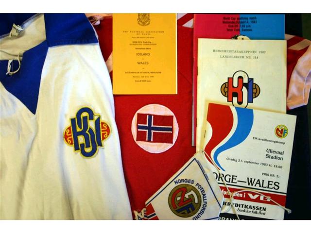 321. International Shirts Etc: A white with blue trim Iceland International Shirt with embroidered badge to front, No. 7 to rear plus itinerary, pin badge, programmes & ceramic tankard relating the match against Wales played in Reykjavik 2nd June 1980 (Giles scored in this match); also a red with white trim V-neck Norway shirt with embroidered badge to front, No.7 to rear plus programme & pennant relating to the match played in Oslo 21st September 1983. £120-150 